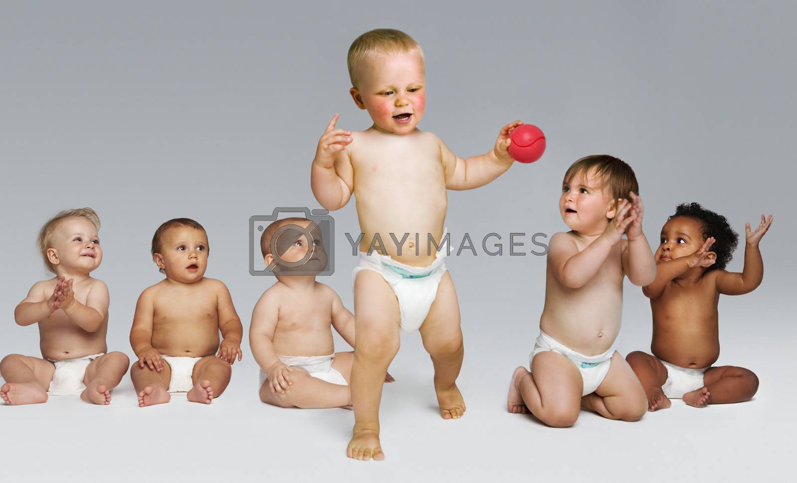 Royalty free image of Toddler takes first steps encouragement of other babies by moodboard