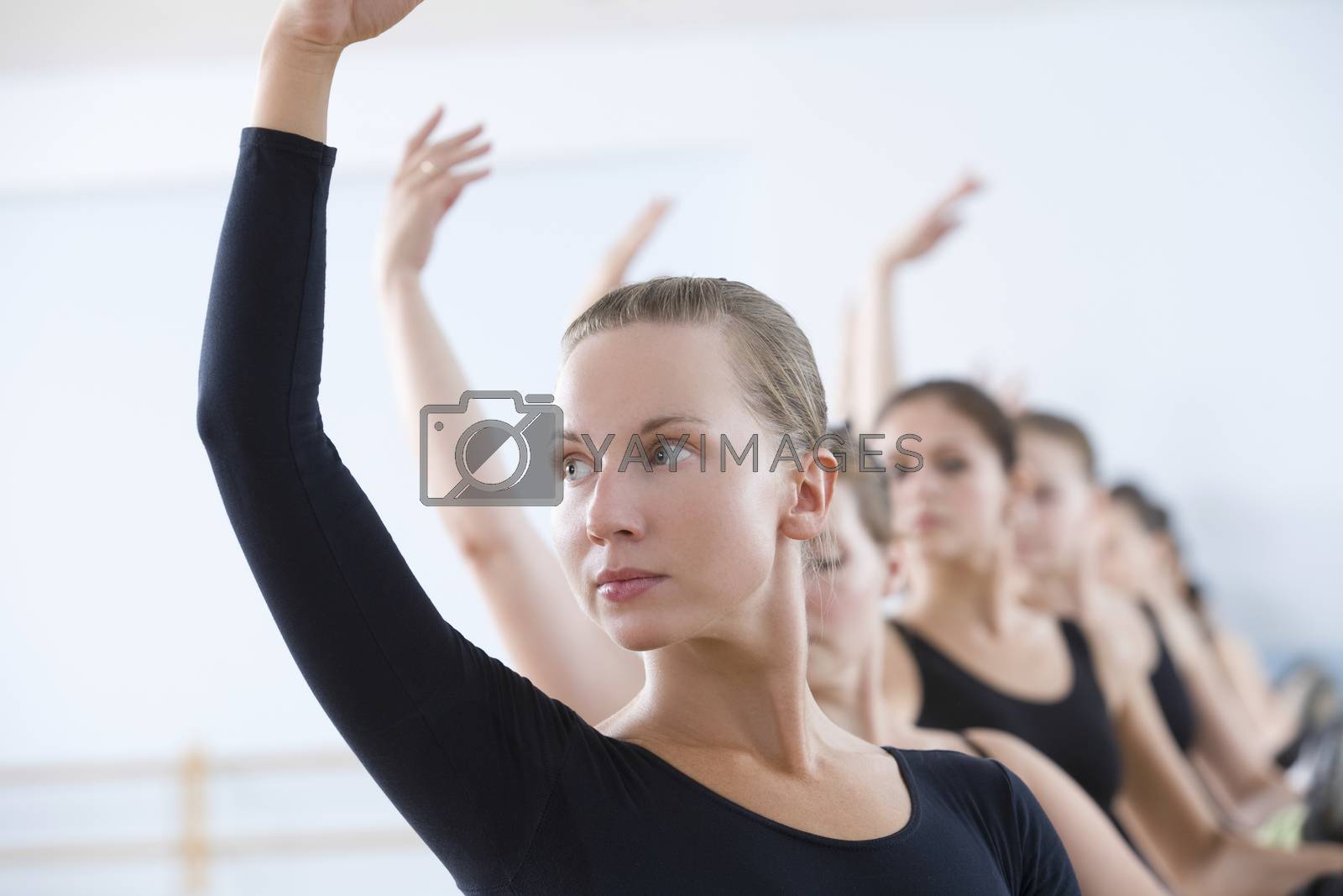 Royalty free image of Young women with arms raised at the barre by moodboard