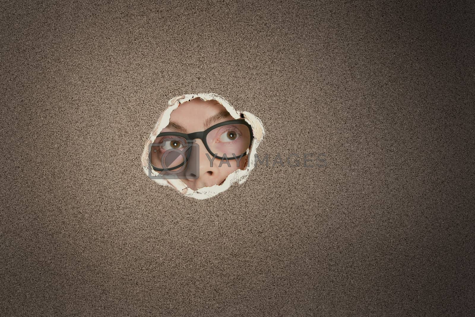 Royalty free image of Mid adult Caucasian man looking away from ripped paper hole by moodboard
