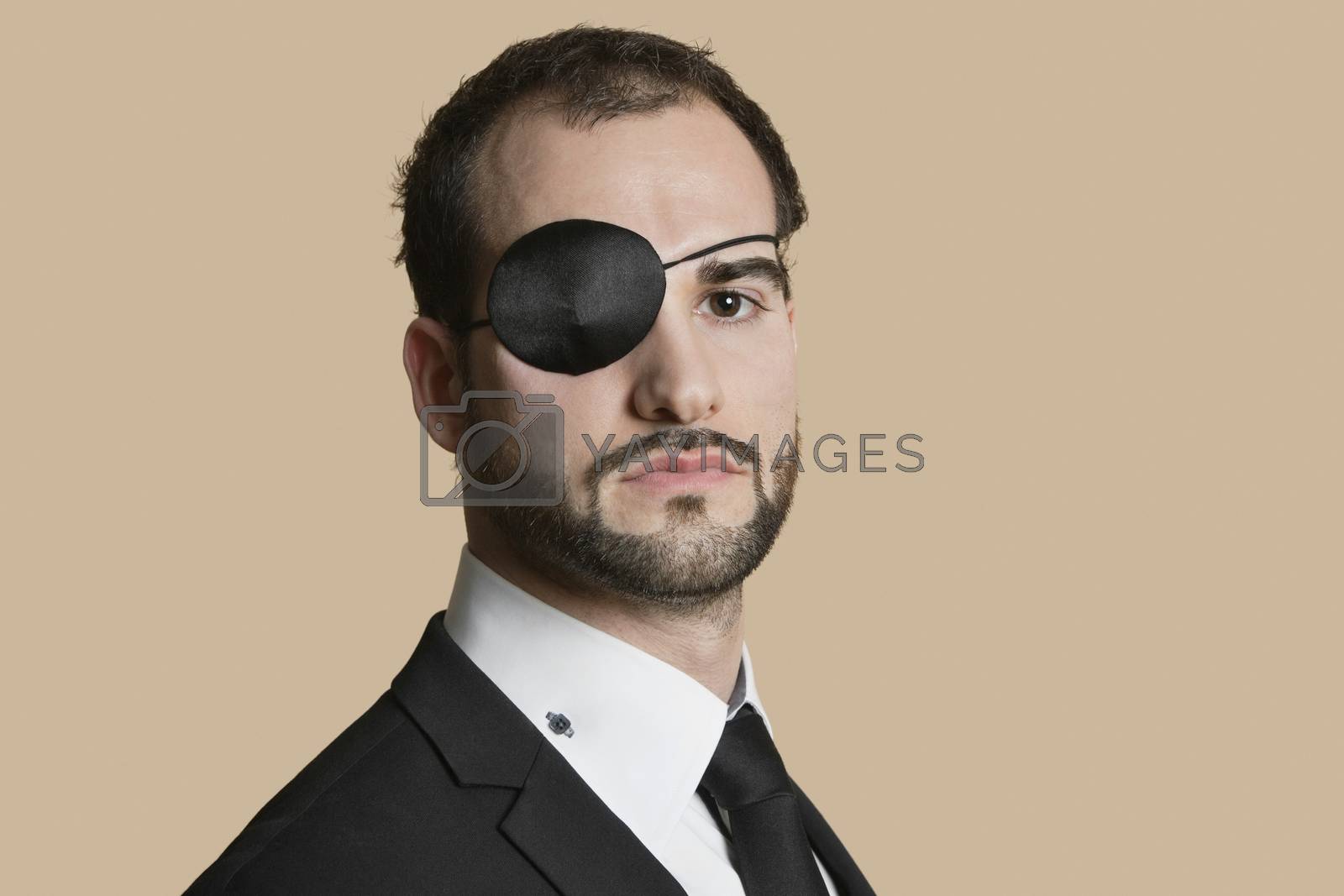 Royalty free image of Portrait of a young businessman with eye patch over colored background by moodboard