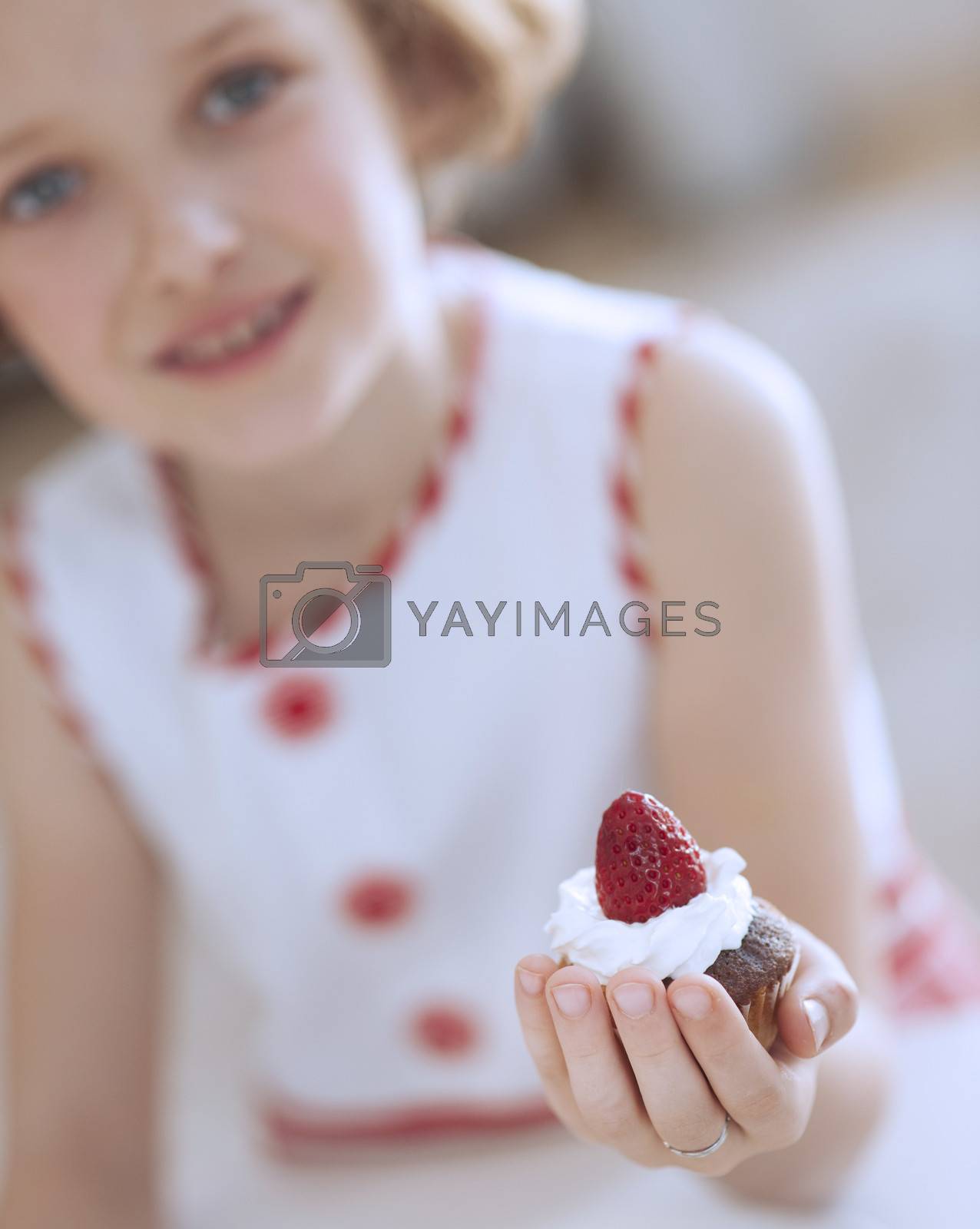 Royalty free image of Young girl holding cup cake by moodboard