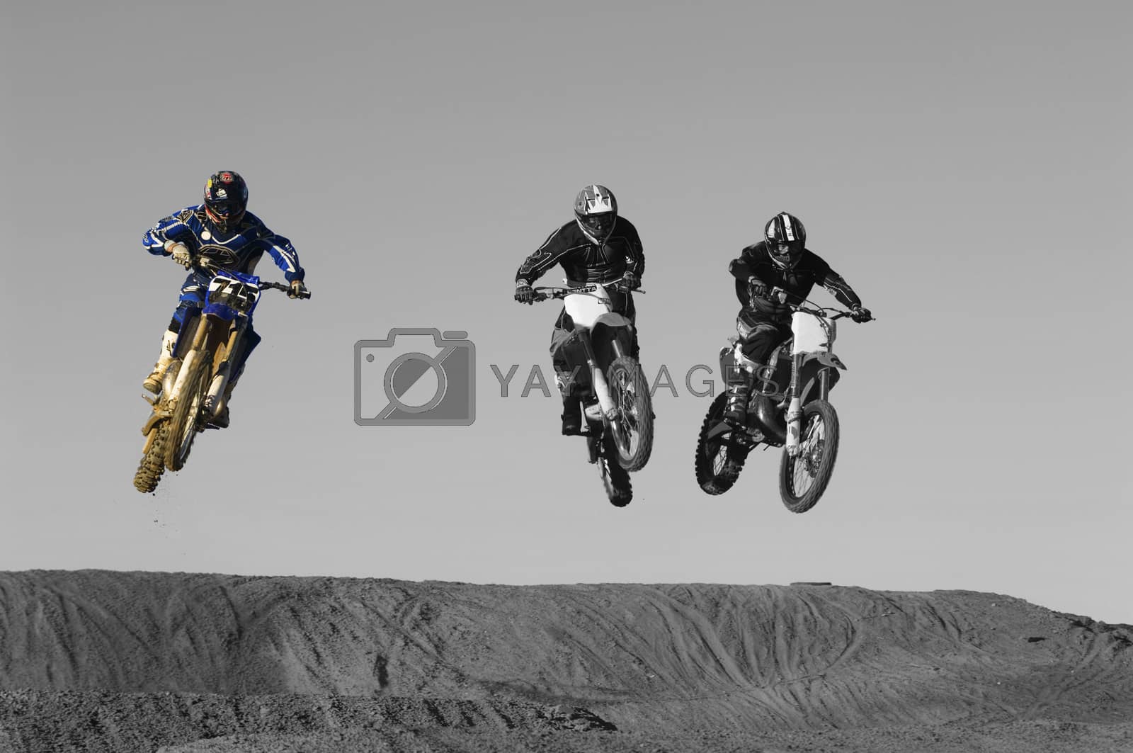 Royalty free image of Young motocross racers riding on dirt track by moodboard