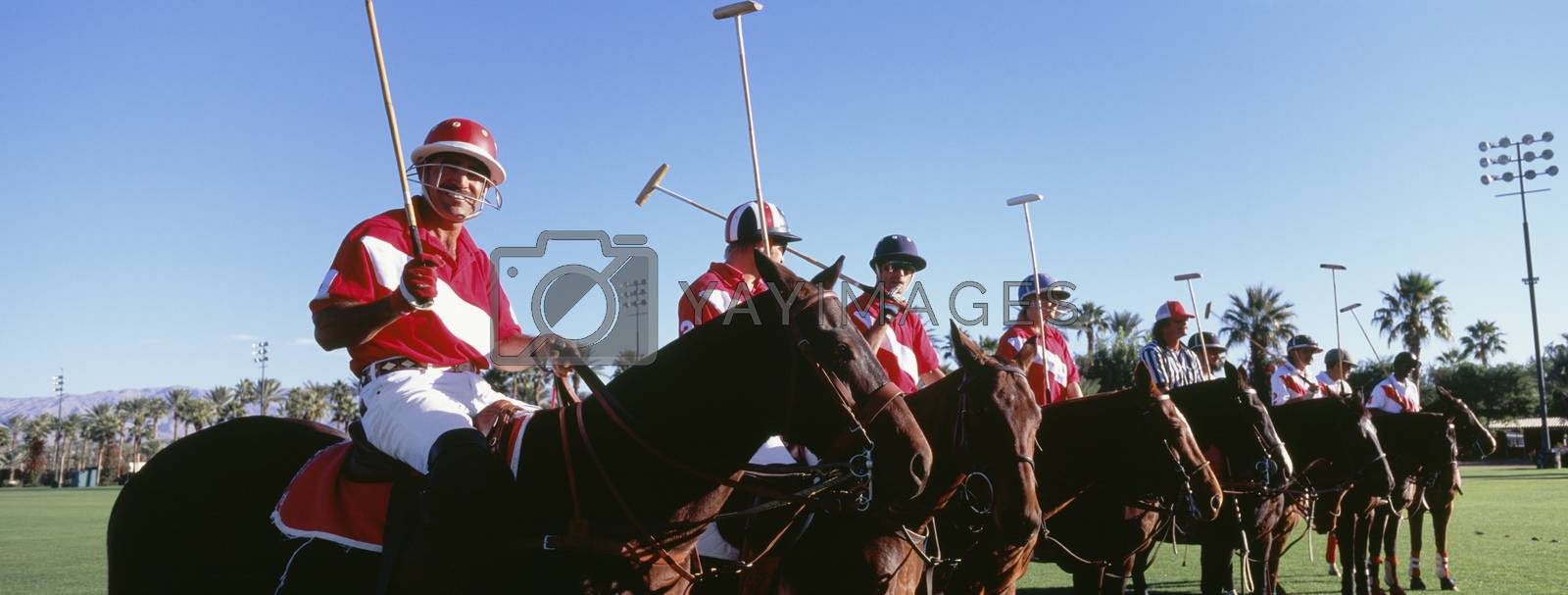 Royalty free image of Panoramic shot of polo players and umpire on horses at field by moodboard