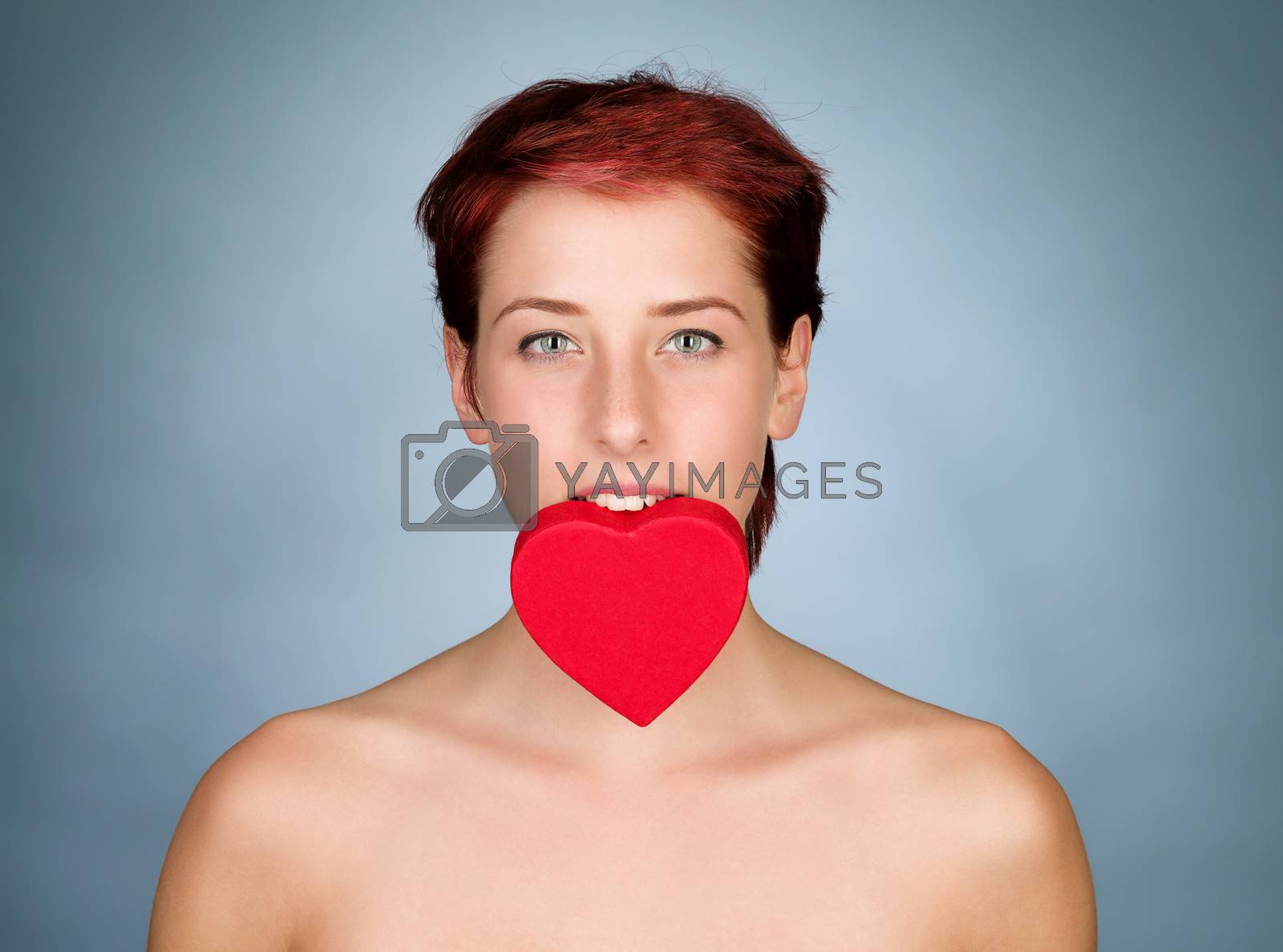 Royalty free image of holding heart with her teeth by RobStark