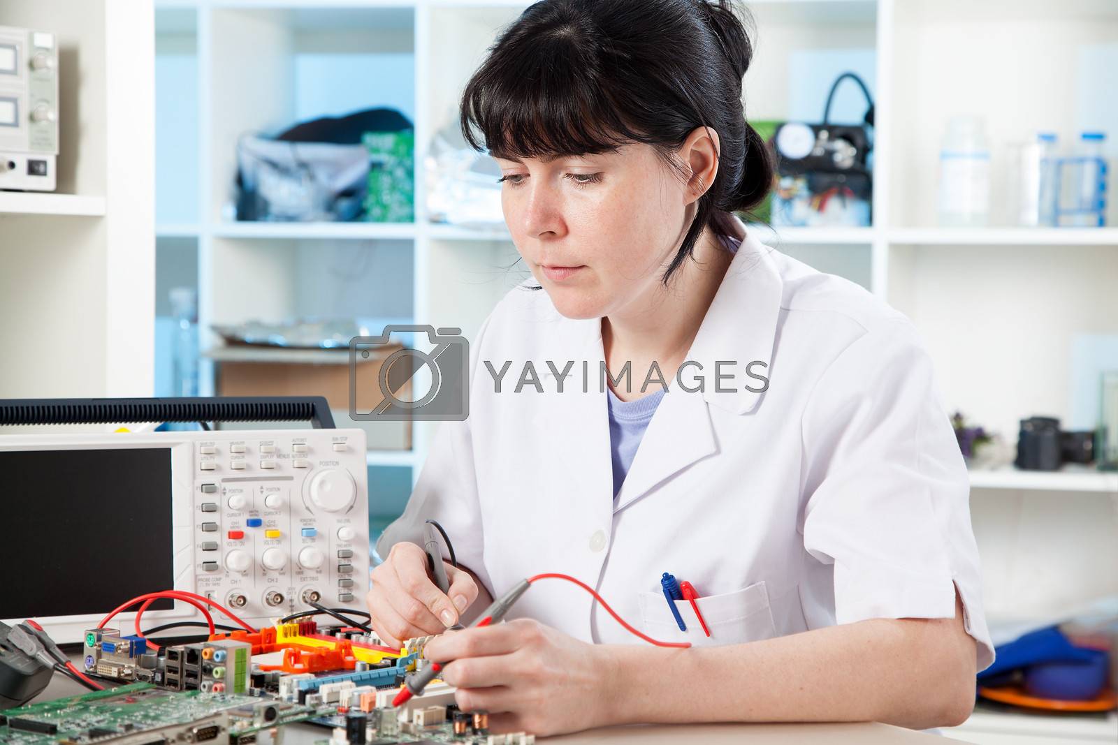 Royalty free image of Tech tests electronic equipment in service centre by motorolka