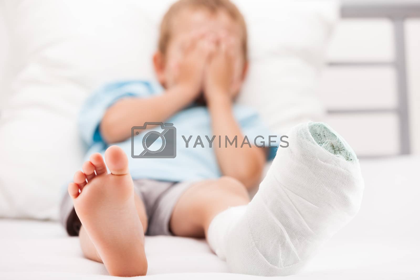 Royalty free image of Little child boy with plaster bandage on leg heel fracture or br by ia_64