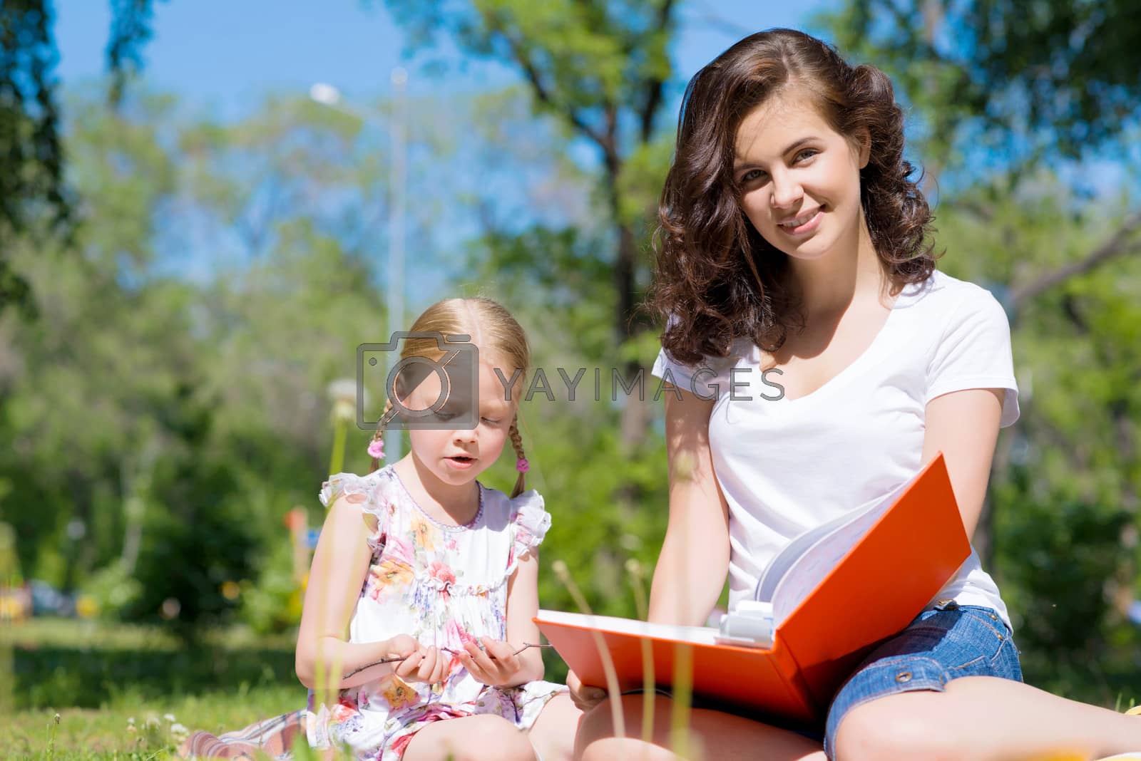 Royalty free image of girl and a young woman reading a book together by adam121