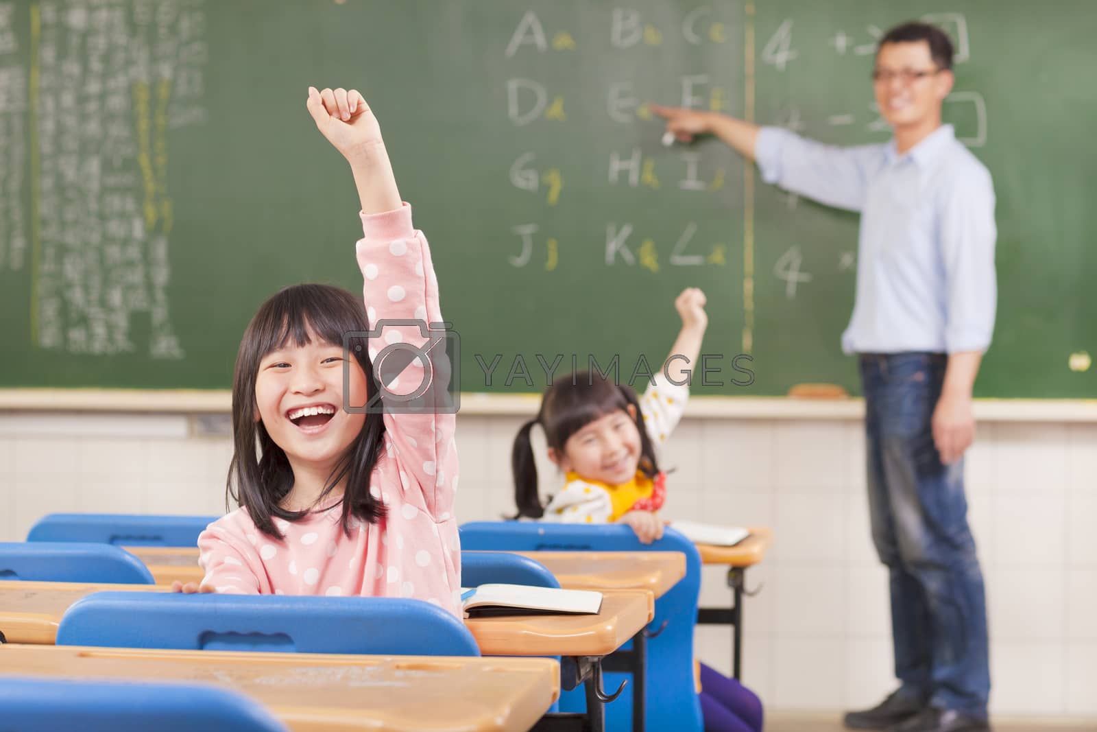 Royalty free image of asian pupils raising hands during the lesson by tomwang