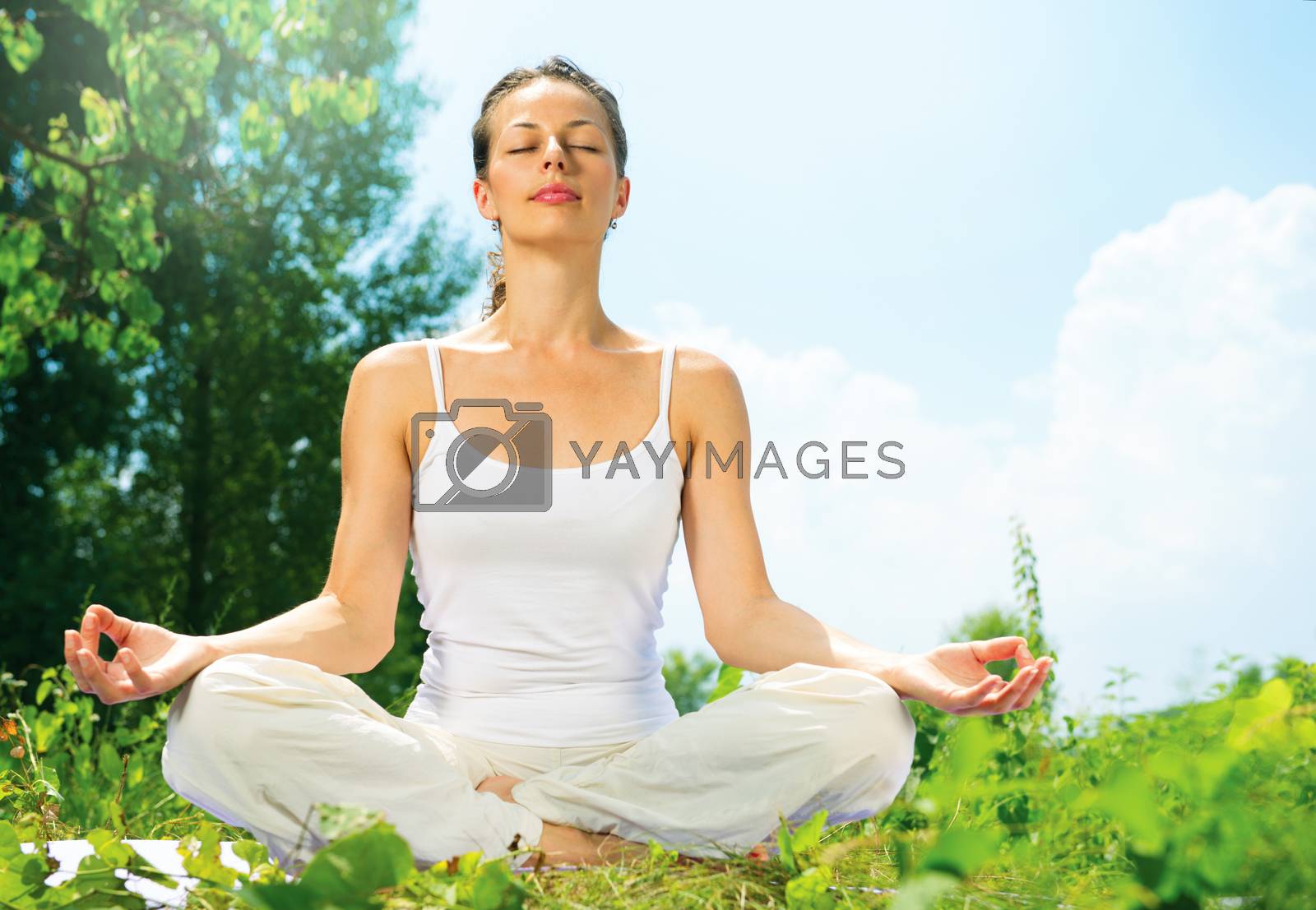 Royalty free image of Young Woman doing Yoga Exercises Outdoor by SubbotinaA