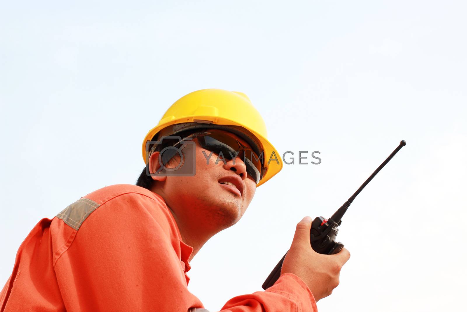 Royalty free image of isolated white background. young man communicating on walkie-talkie at site by ZONETEEn