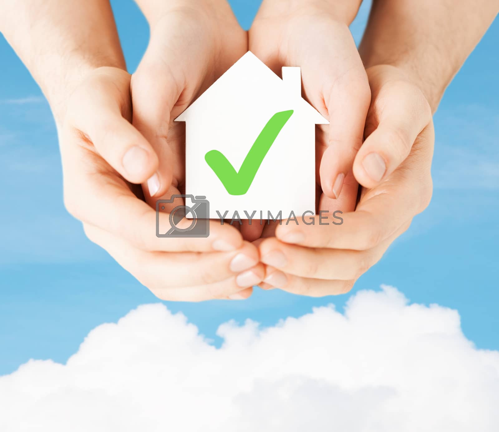 Royalty free image of hands holding house with check mark by dolgachov