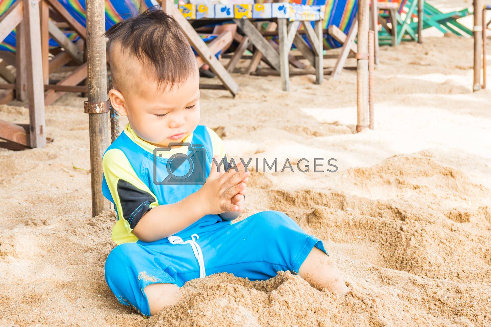 Royalty free image of Asian cute boy playing sand on the beach by punsayaporn