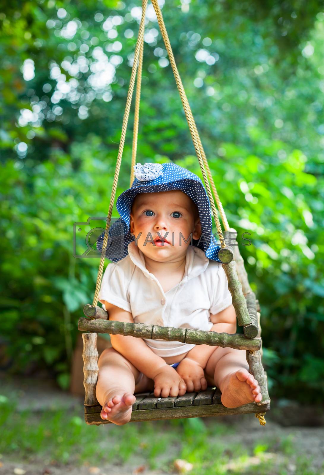 Royalty free image of Infant on a swing by naumoid