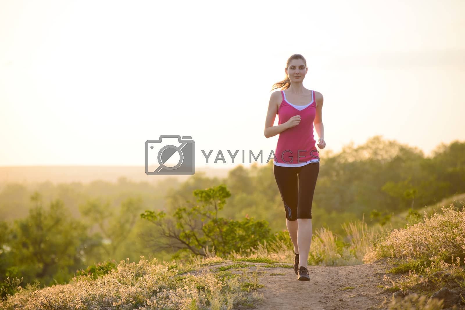 Royalty free image of Young Beautiful Woman Running on Mountain Trail in the Morning by maxpro