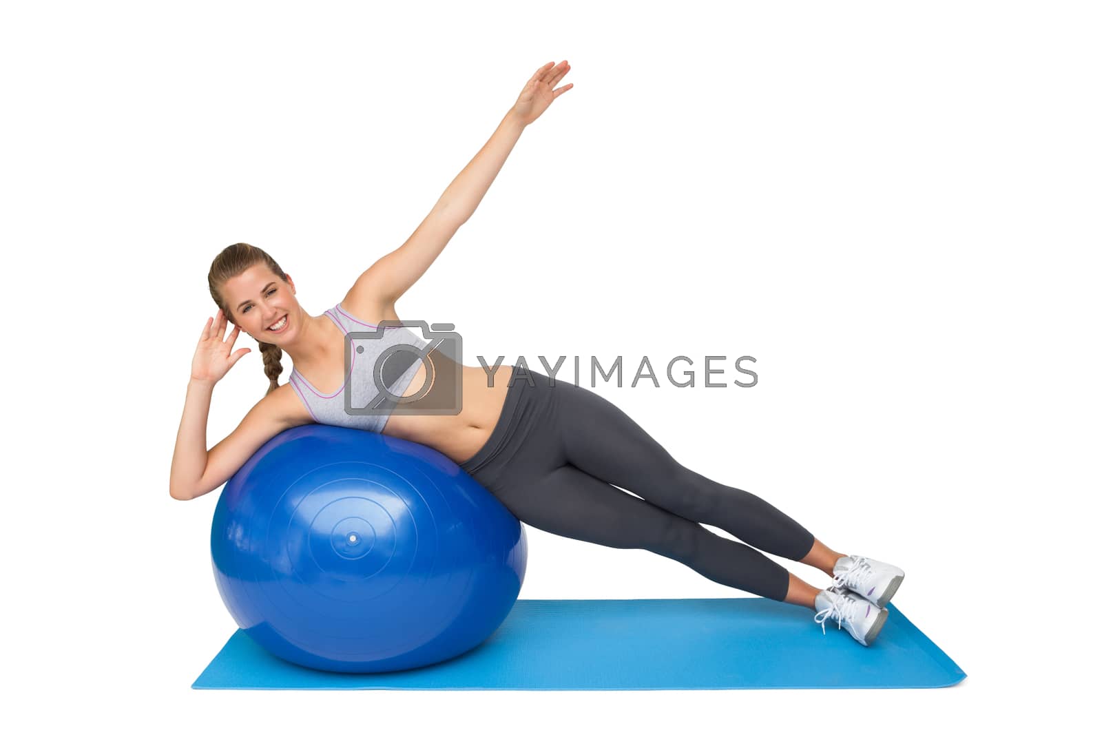 Royalty free image of Portrait of a fit woman stretching on fitness ball by Wavebreakmedia