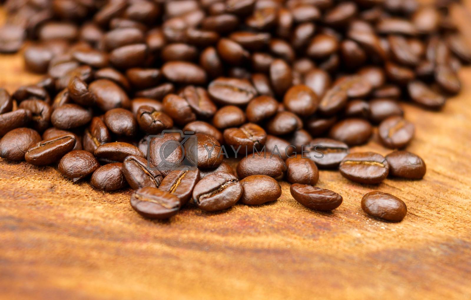 Royalty free image of Roasted coffee beans on wood. (Arabica coffee) by Noppharat_th