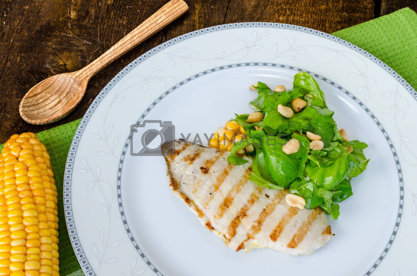 Royalty free image of Chicken steak with garlic and lemon, salad by Peteer