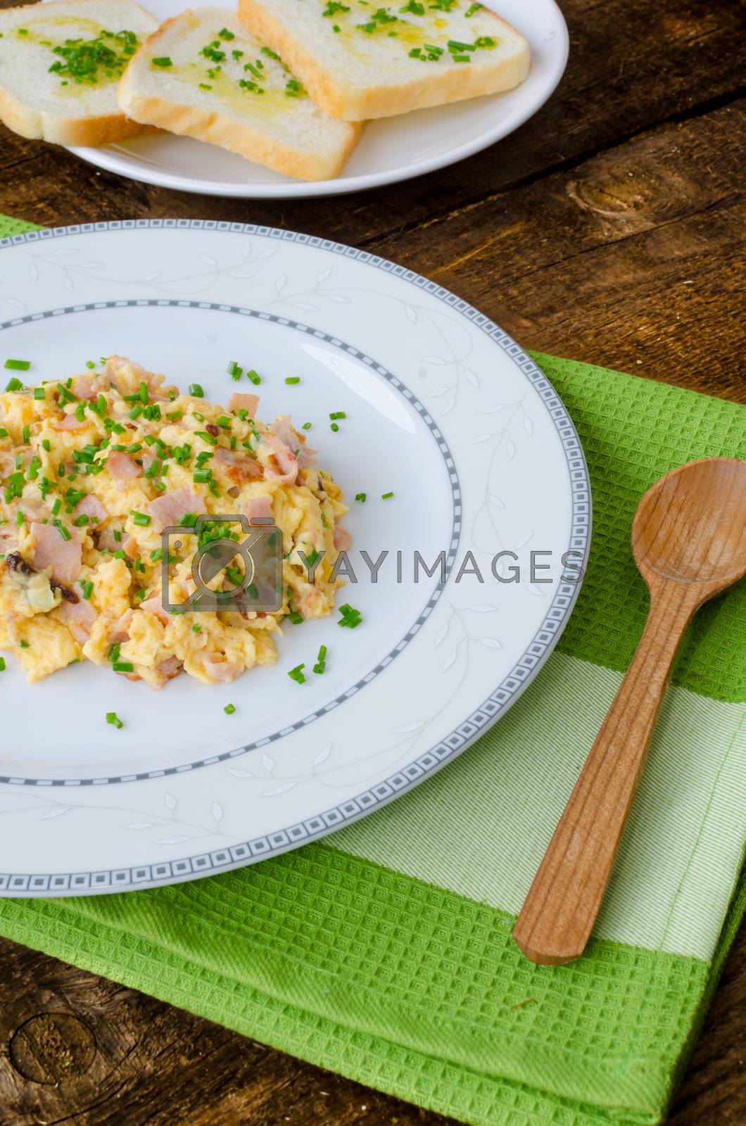 Royalty free image of Scrambled eggs with chive and bacon, toast with herbs by Peteer