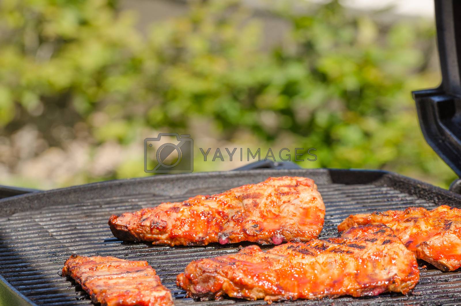 Royalty free image of Spareribs on grill with hot marinade by Peteer