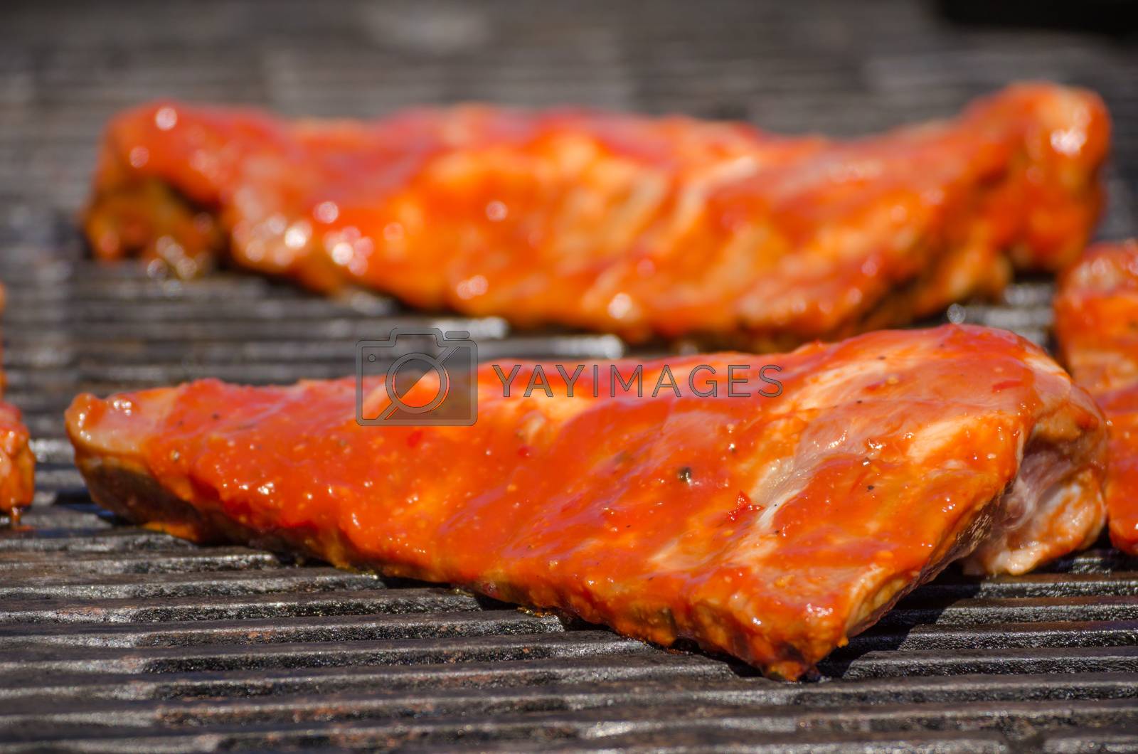 Royalty free image of Spareribs on grill with hot marinade by Peteer