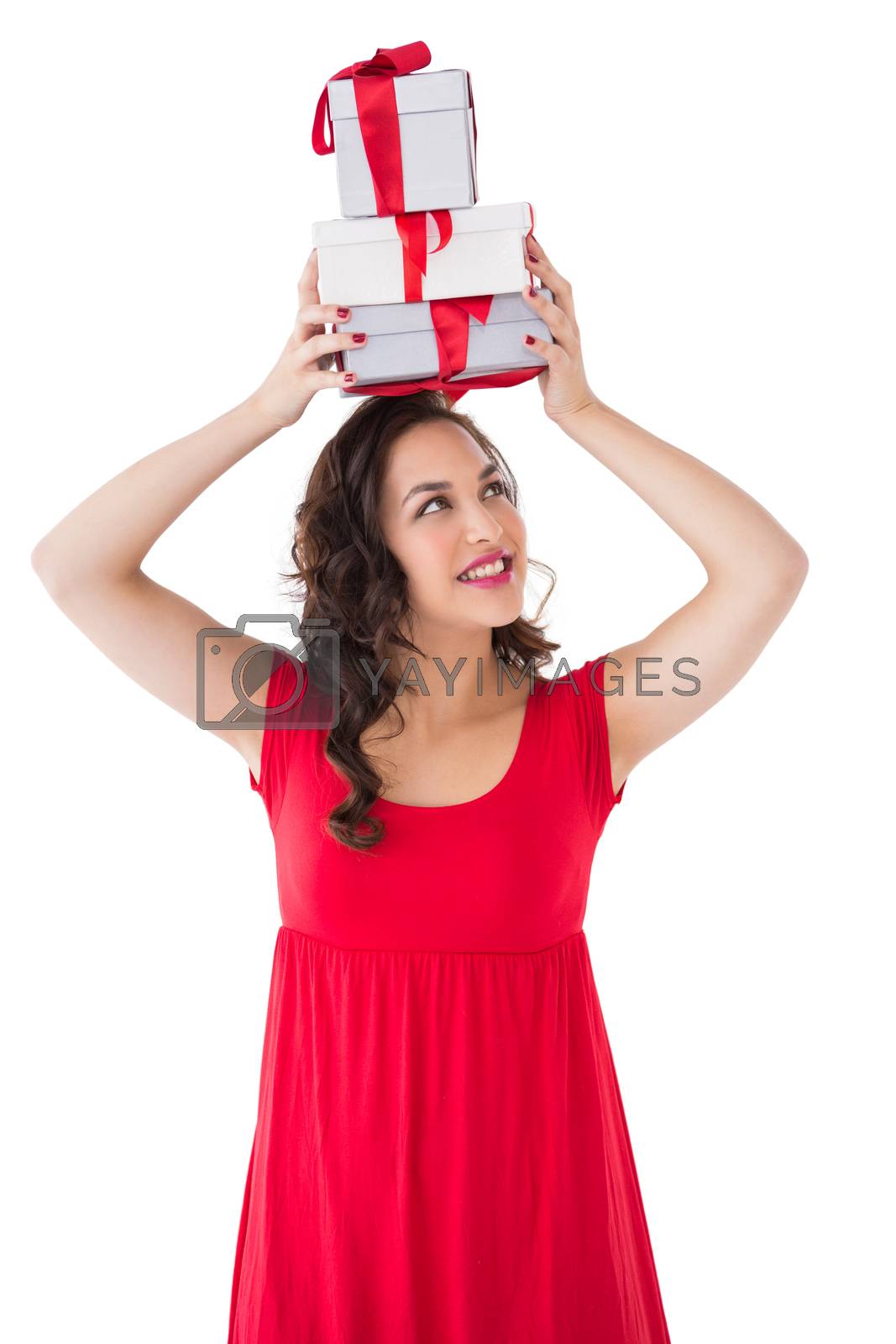 Royalty free image of Happy brunette in red dress holding many gifts by Wavebreakmedia
