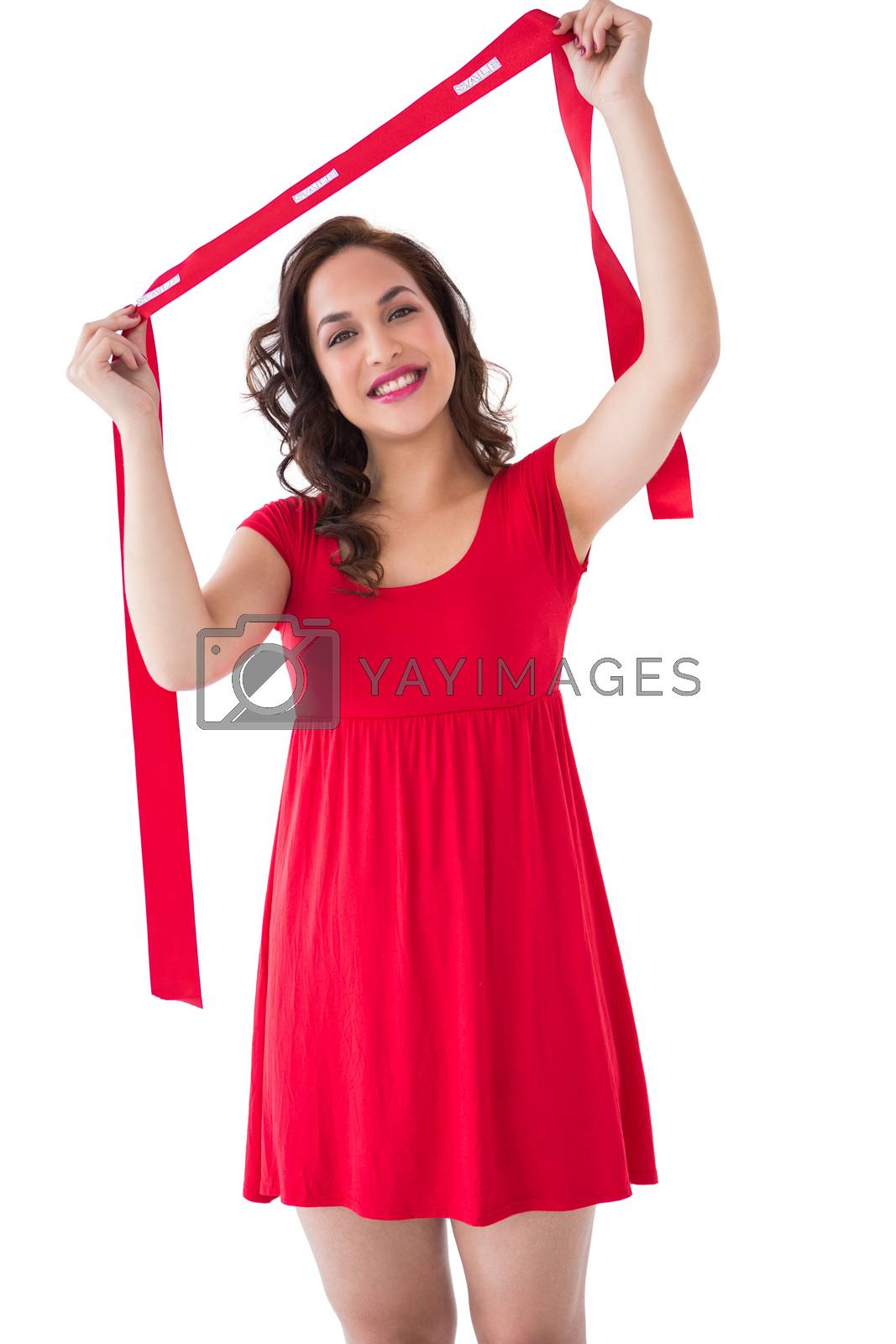 Royalty free image of Happy brunette in red dress holding scarf  by Wavebreakmedia