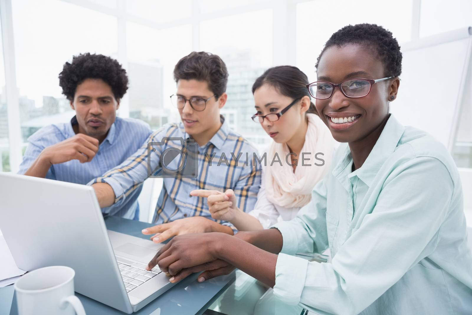 Royalty free image of Casual business team having a meeting using laptop by Wavebreakmedia