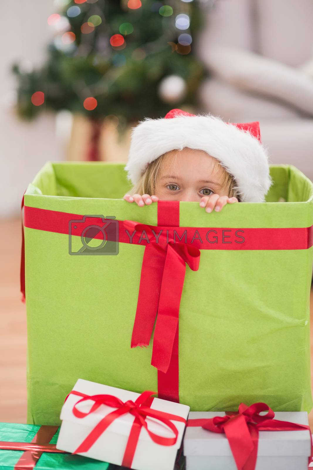 Royalty free image of Cute little girl sitting in giant christmas gift by Wavebreakmedia
