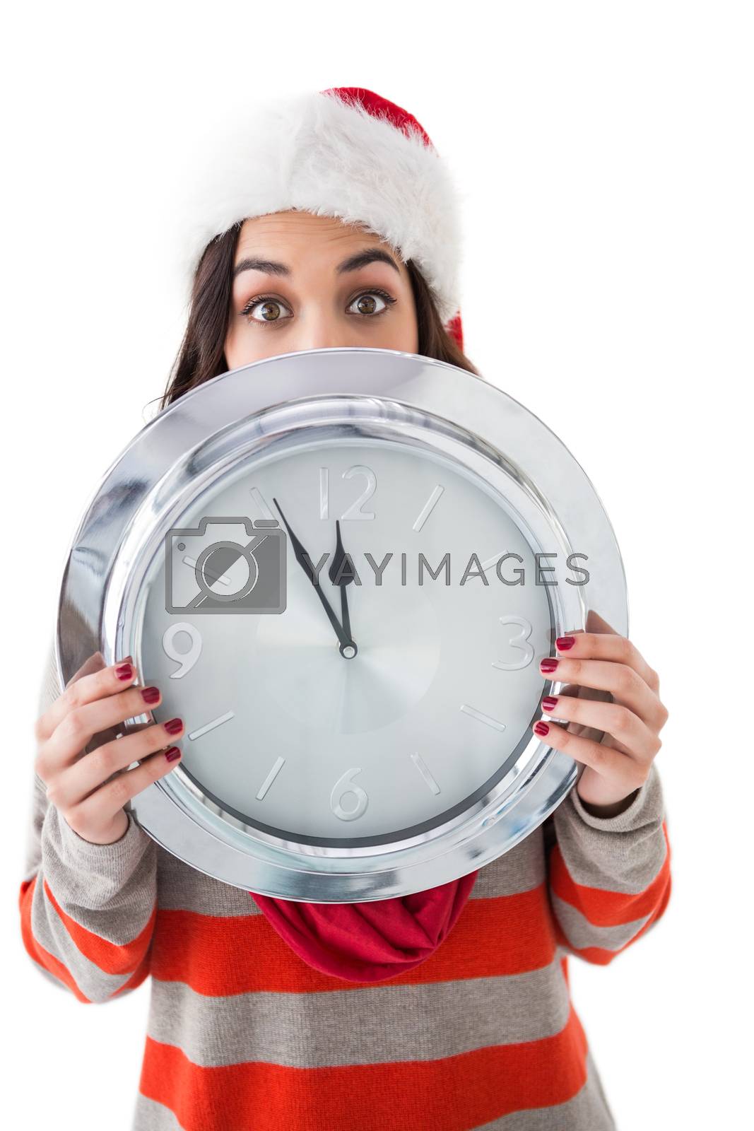 Royalty free image of Festive brunette holding a clock by Wavebreakmedia