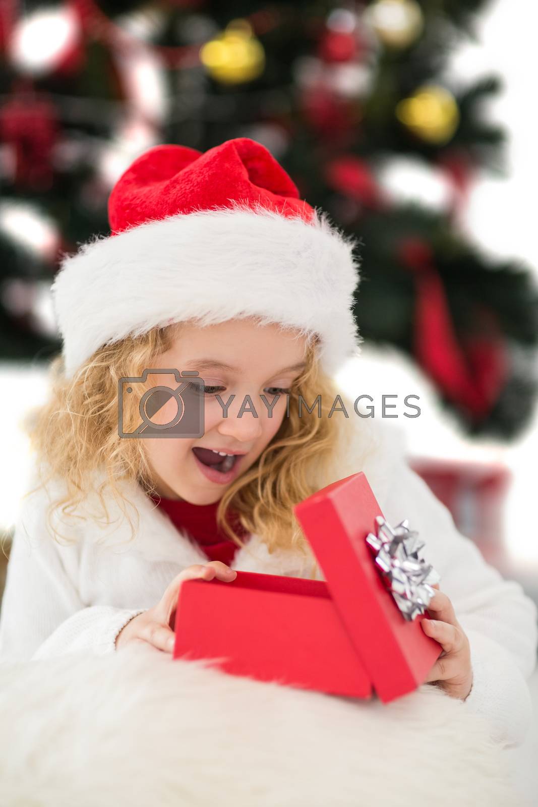 Royalty free image of Festive little girl looking at gift by Wavebreakmedia