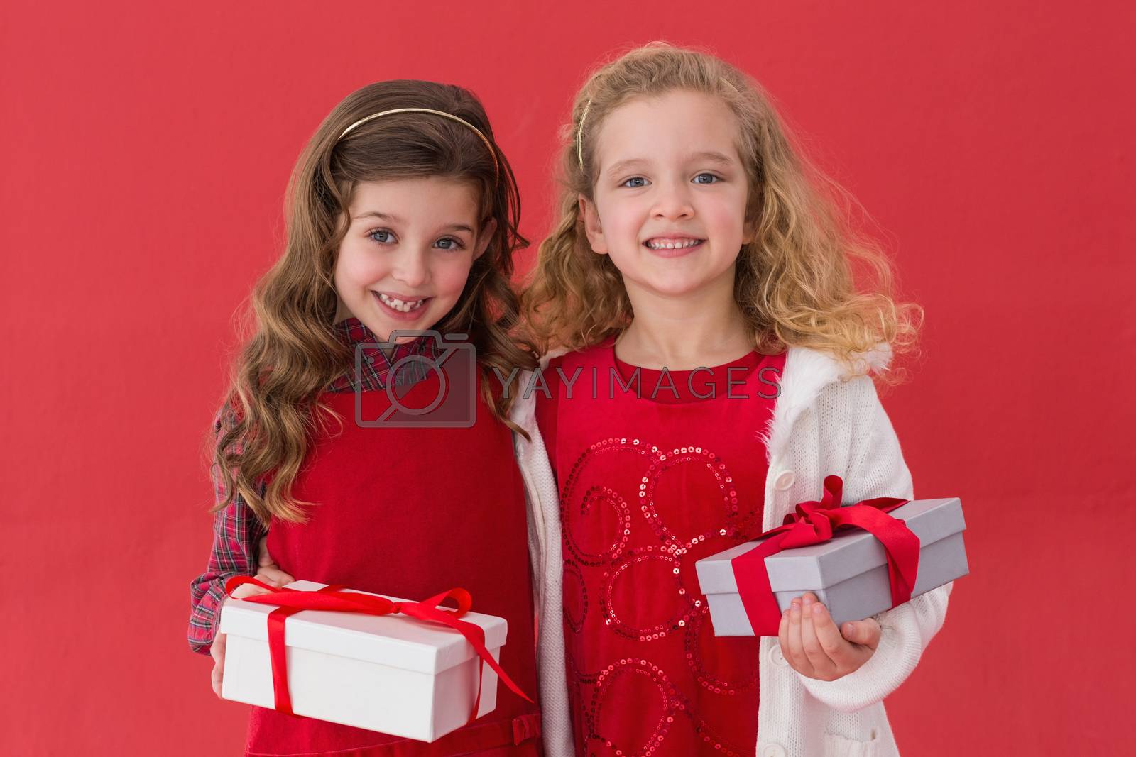 Royalty free image of Festive little girls holding gifts by Wavebreakmedia