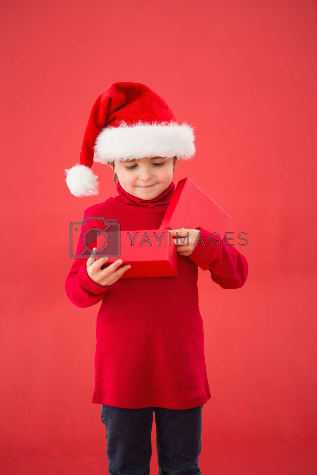 Royalty free image of Festive little boy opening a gift by Wavebreakmedia