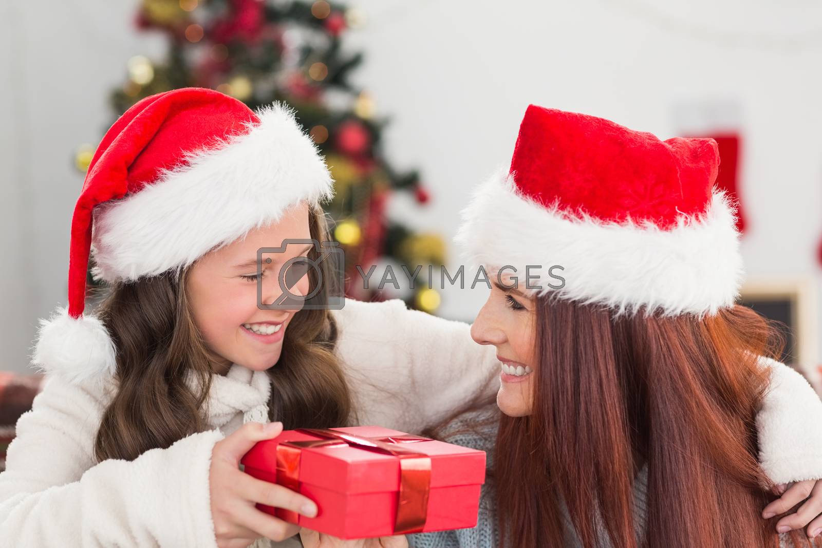 Royalty free image of Festive mother and daughter smiling at each other by Wavebreakmedia
