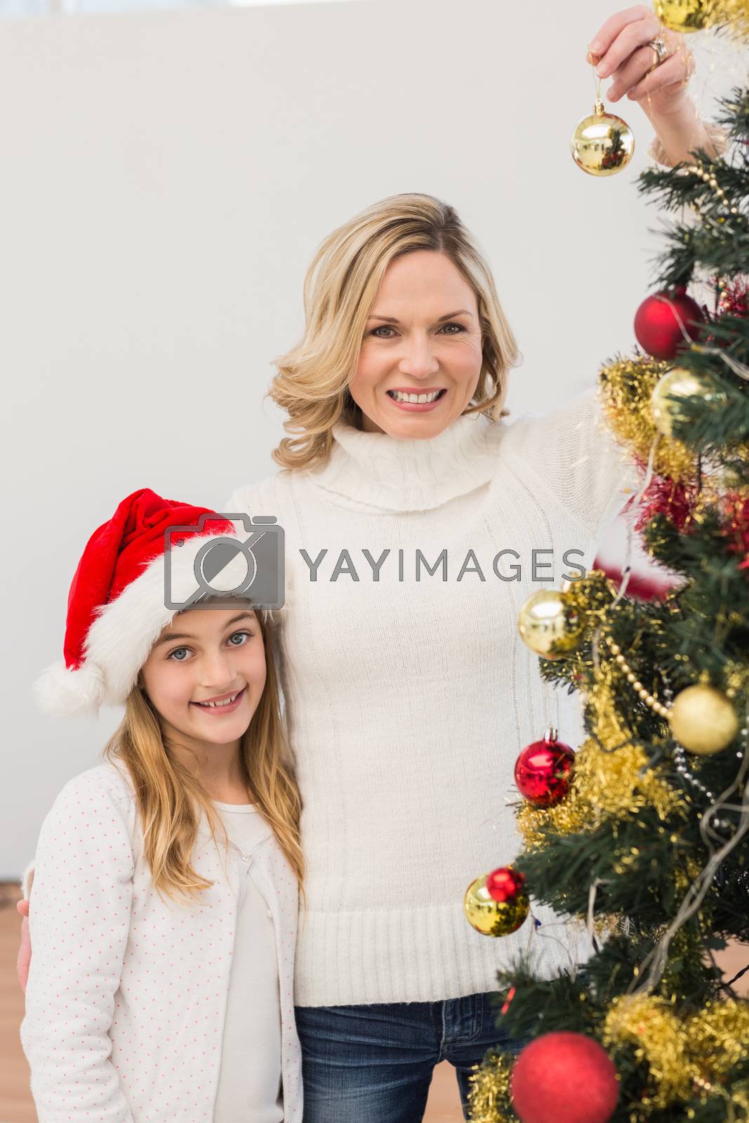 Royalty free image of Festive mother and daughter decorating christmas tree by Wavebreakmedia
