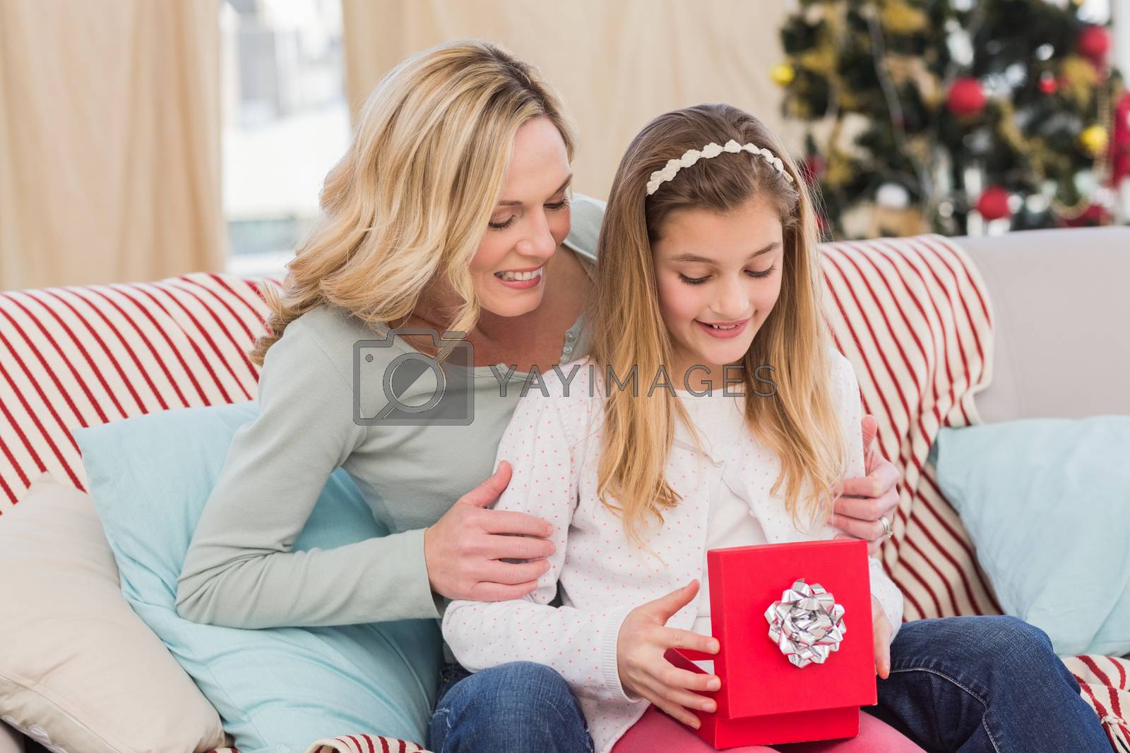Royalty free image of Daughter opening christmas gift with mother by Wavebreakmedia