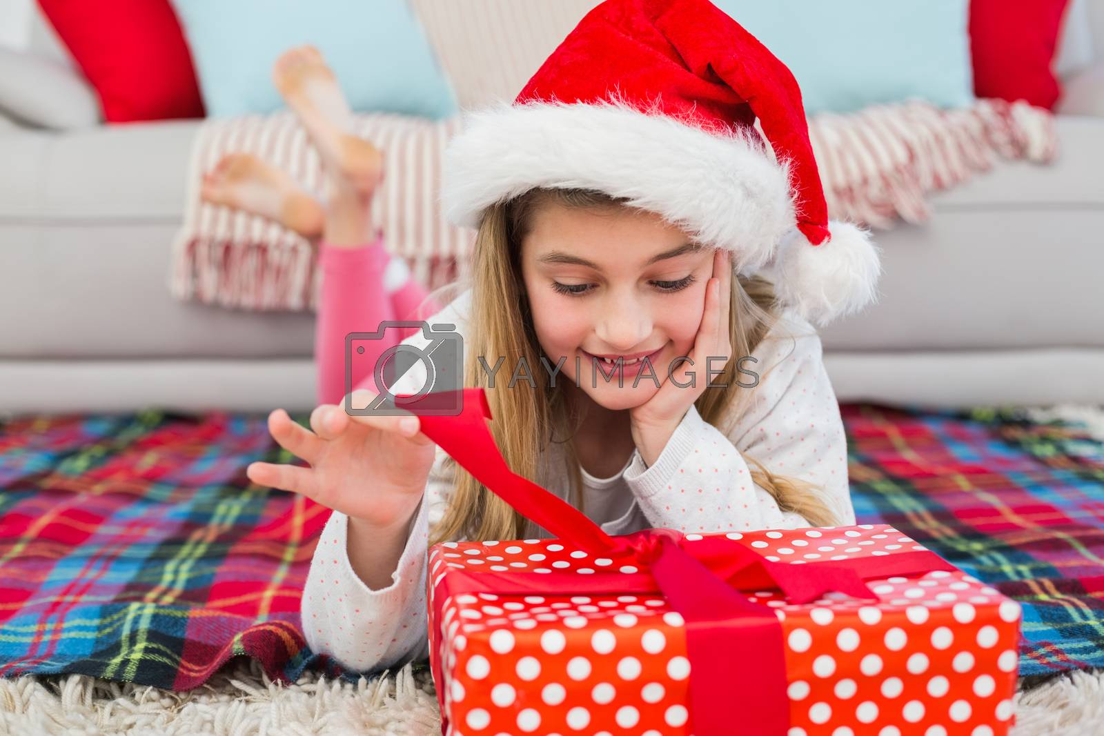 Royalty free image of Festive little girl opening a gift by Wavebreakmedia