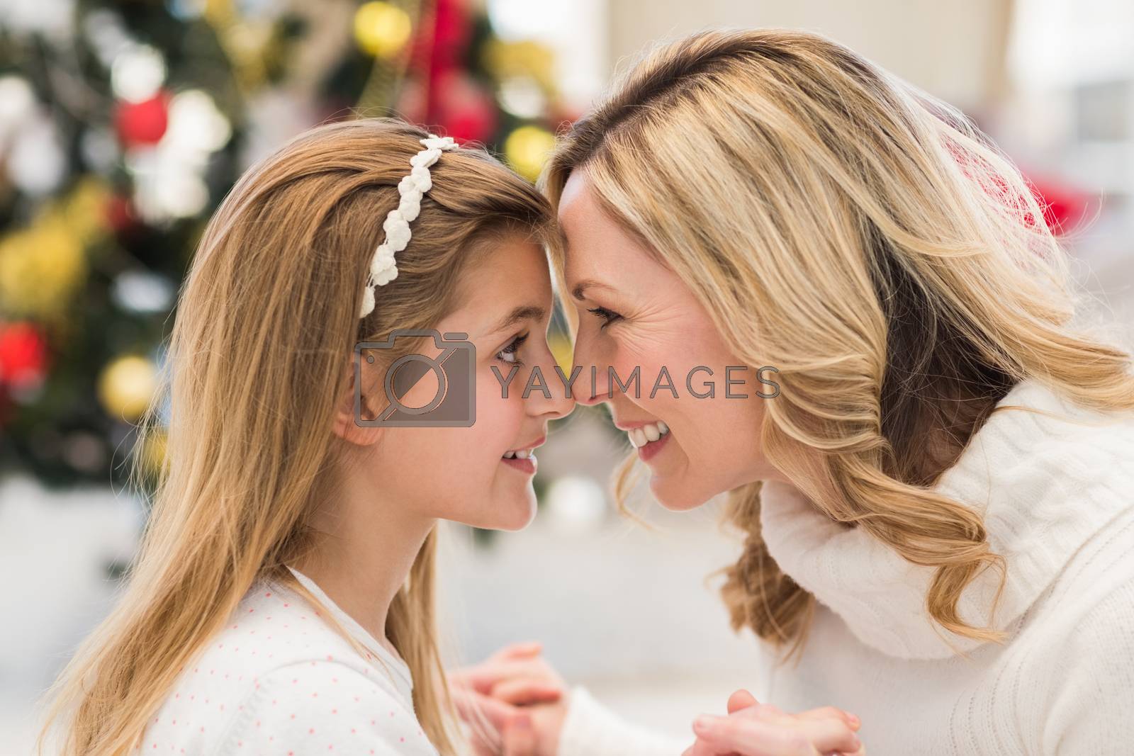 Royalty free image of Festive mother and daughter beside christmas tree by Wavebreakmedia