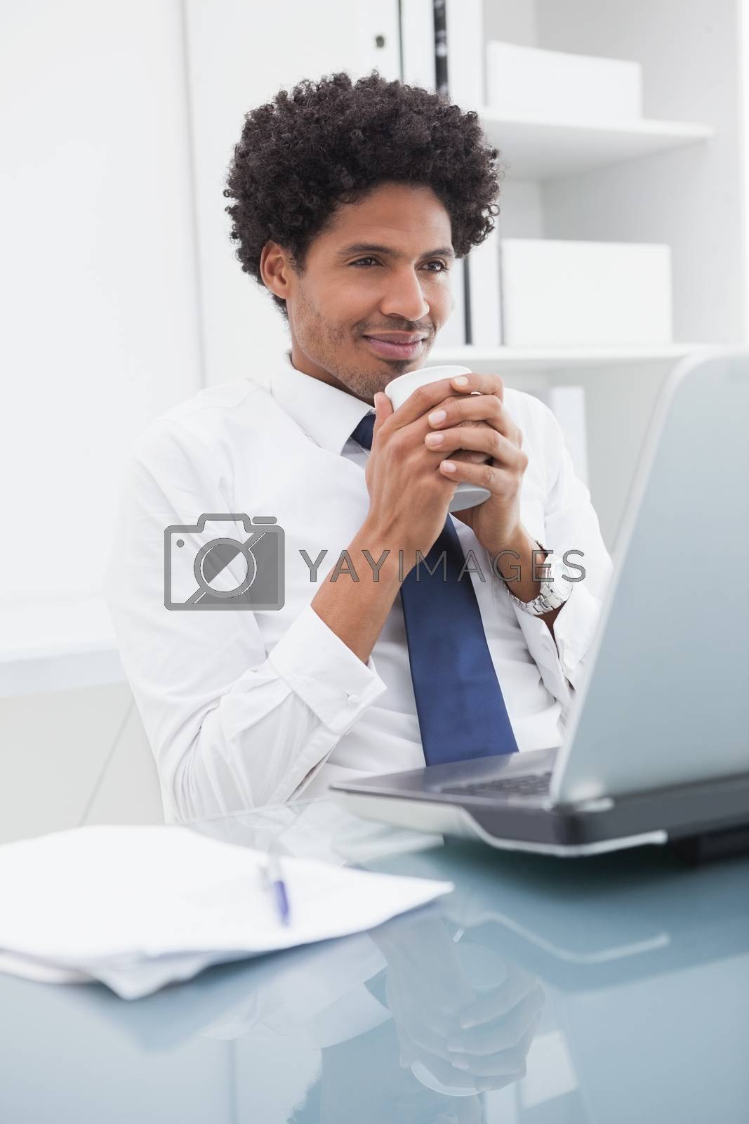 Royalty free image of Cheerful businessman enjoying hot drink by Wavebreakmedia