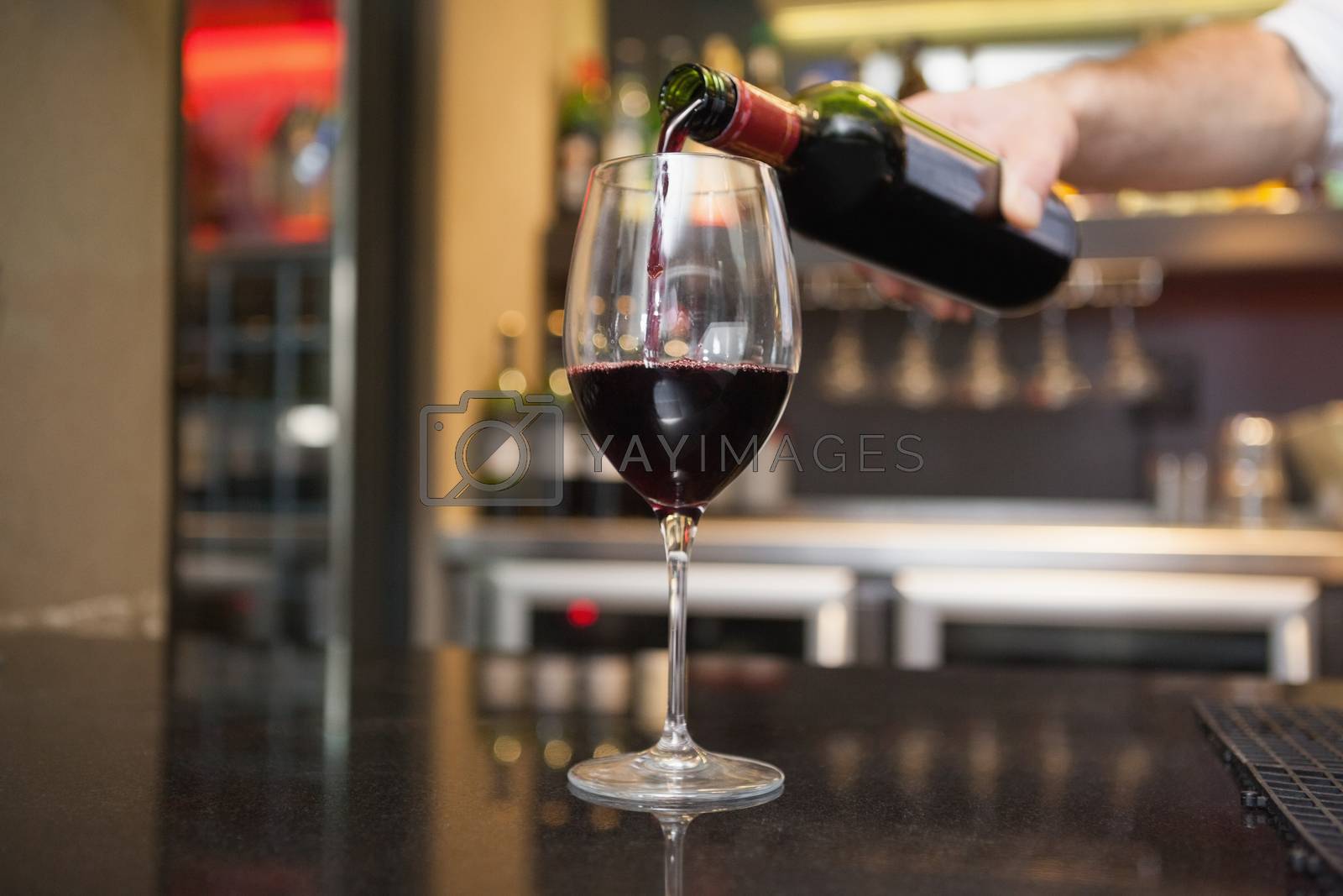 Royalty free image of Hand pouring red wine into glass by Wavebreakmedia