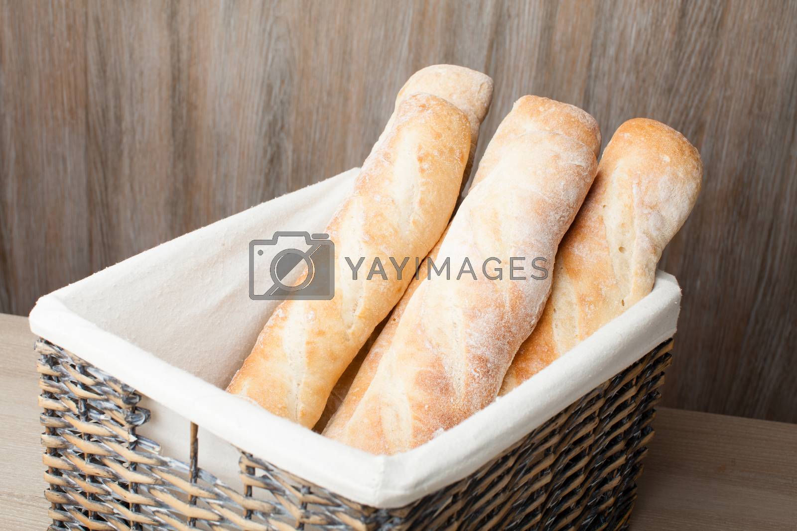 Royalty free image of Loafs of traditional French bread baguette stocked in woven bask by SergeyAK