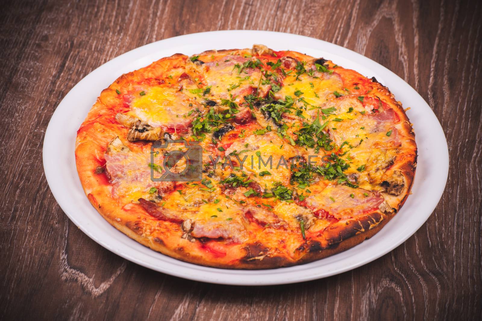 Royalty free image of pizza with ham on white plate  by fesenko