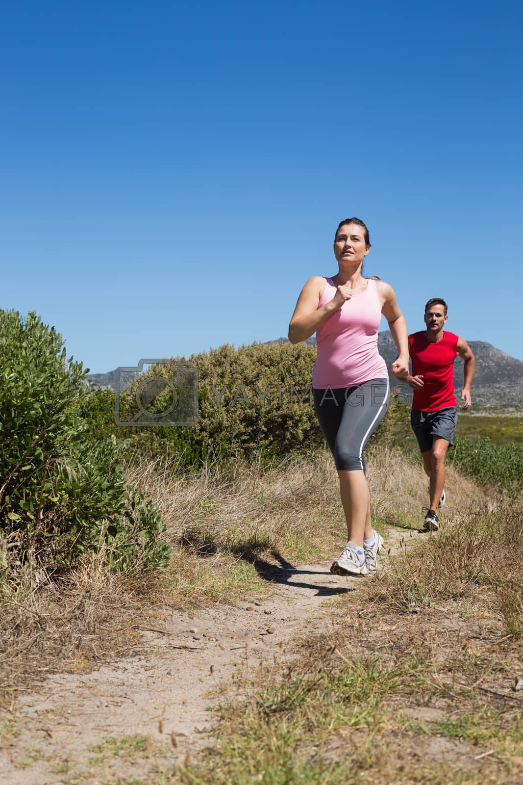 Royalty free image of Active couple jogging on country terrain by Wavebreakmedia