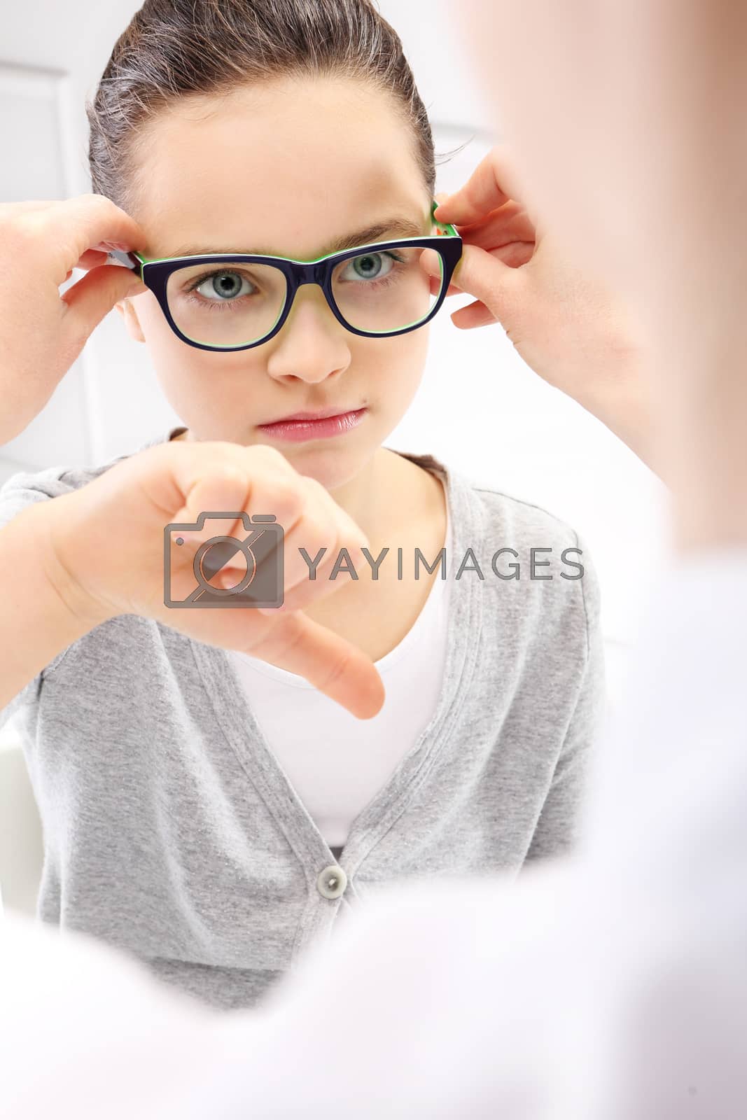 Royalty free image of Selection of glasses, a little girl with an ophthalmologist. by robert_przybysz