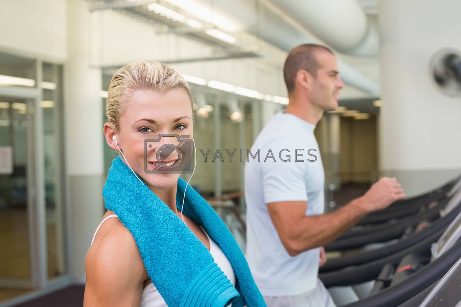 Royalty free image of Fit young couple running on treadmills at gym by Wavebreakmedia