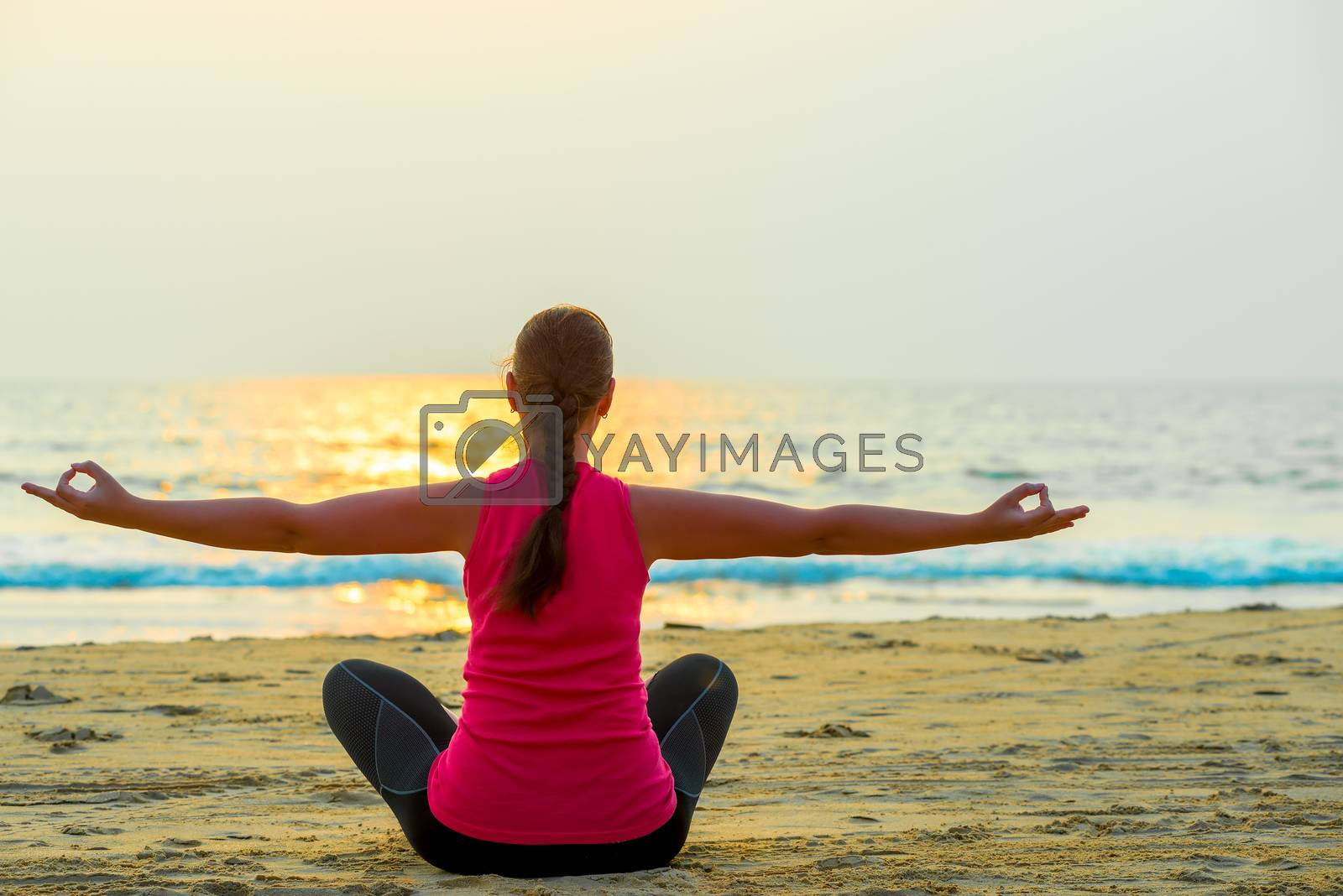 Royalty free image of woman alone does yoga at sunset on the sea by kosmsos111