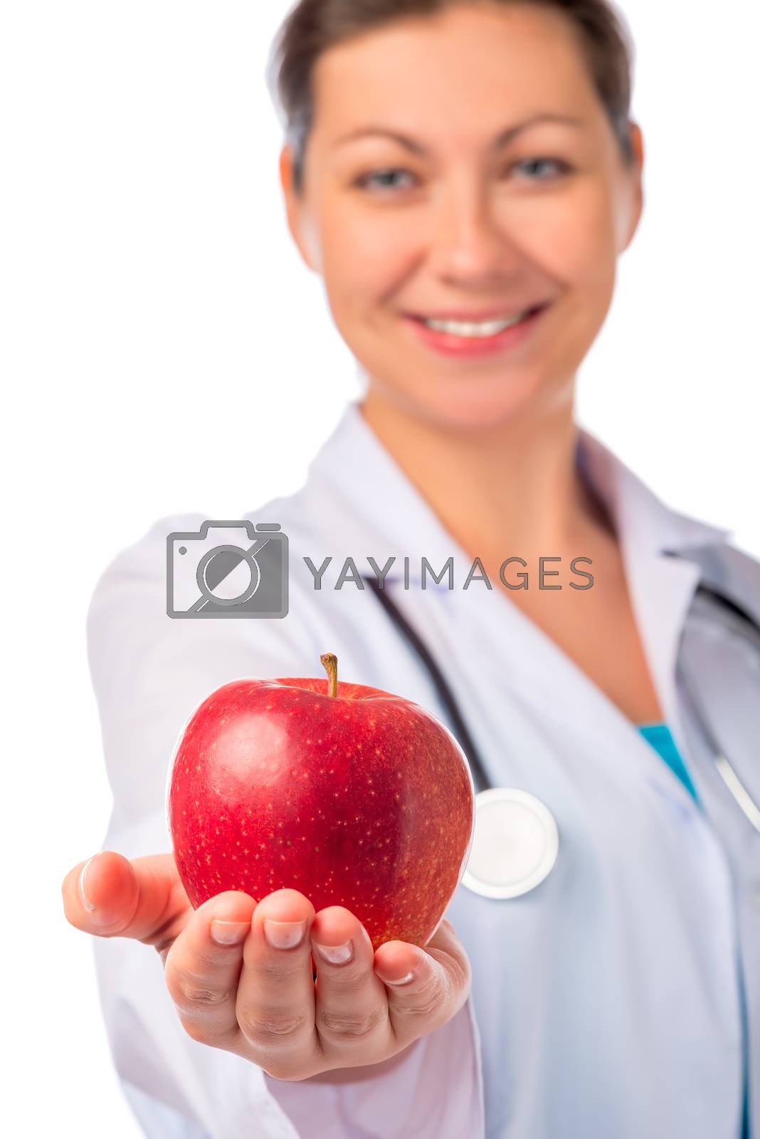 Royalty free image of Smiling doctor holding a red apple in the palm by kosmsos111