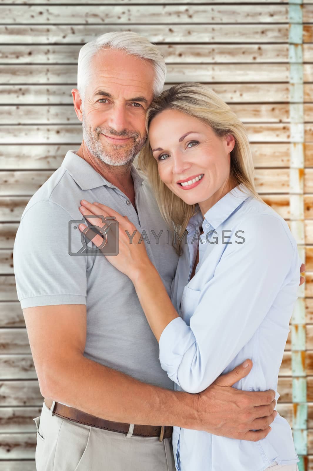 Royalty free image of Composite image of happy couple standing and smiling at camera by Wavebreakmedia