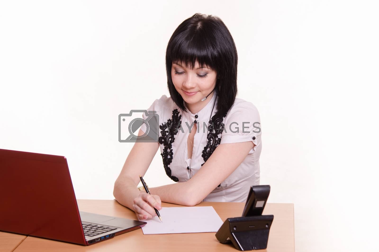 Royalty free image of Call-center employee at his desk writes by Madhourse