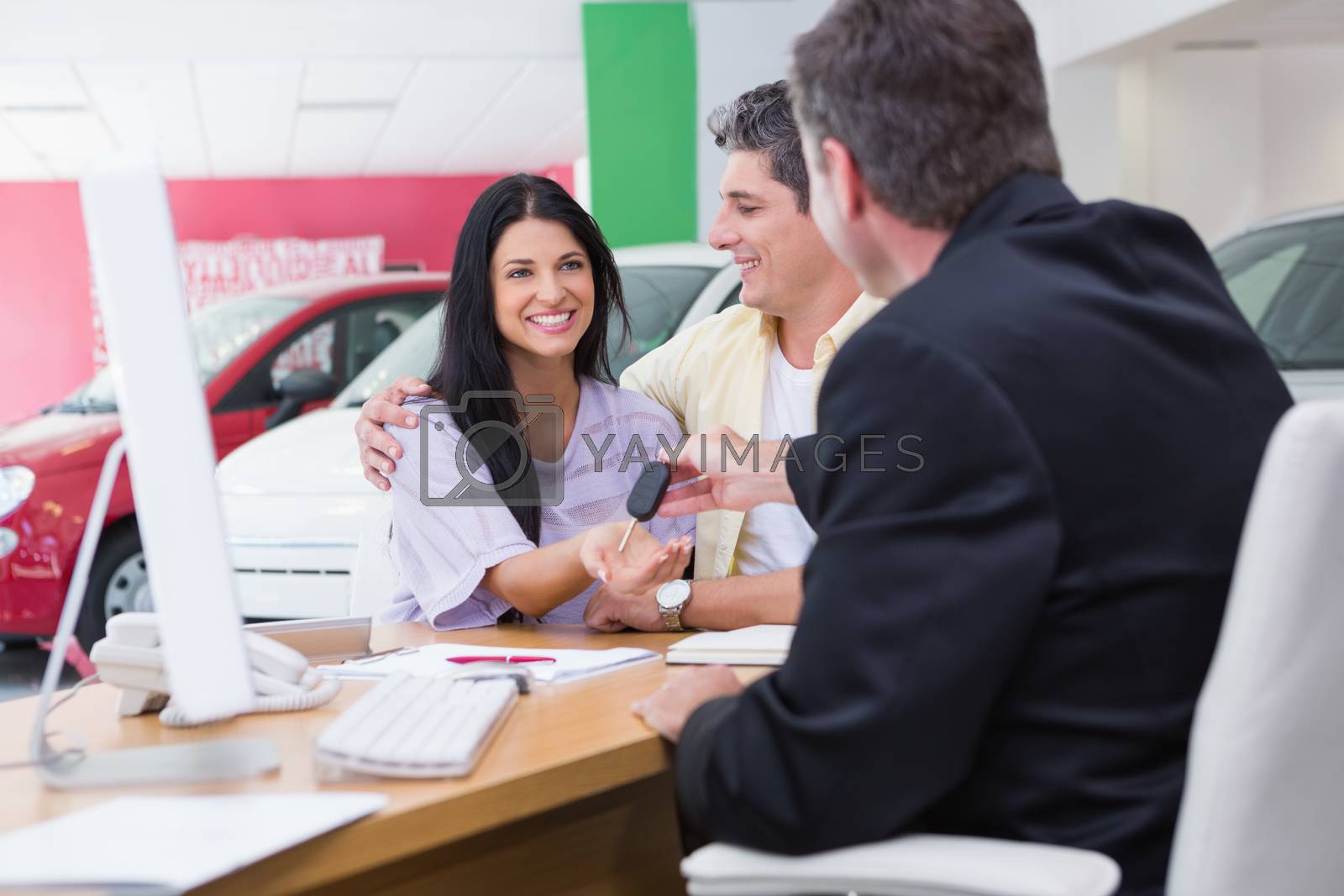 Royalty free image of Salesman giving car keys to a couple by Wavebreakmedia