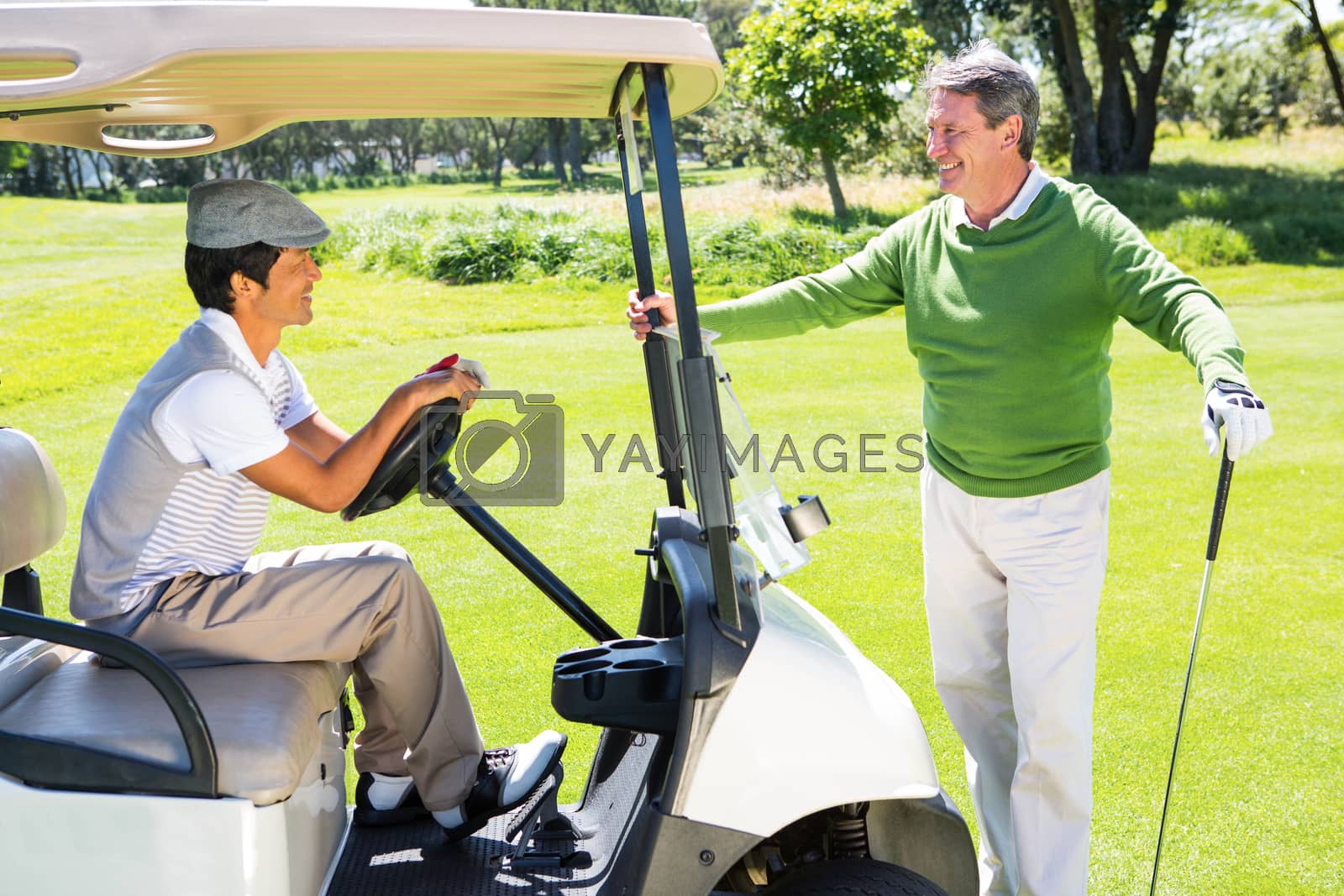 Royalty free image of Happy golfing friends setting out for the day on buggy by Wavebreakmedia